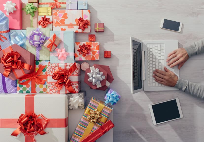homme commande cadeaux noel sur laptop